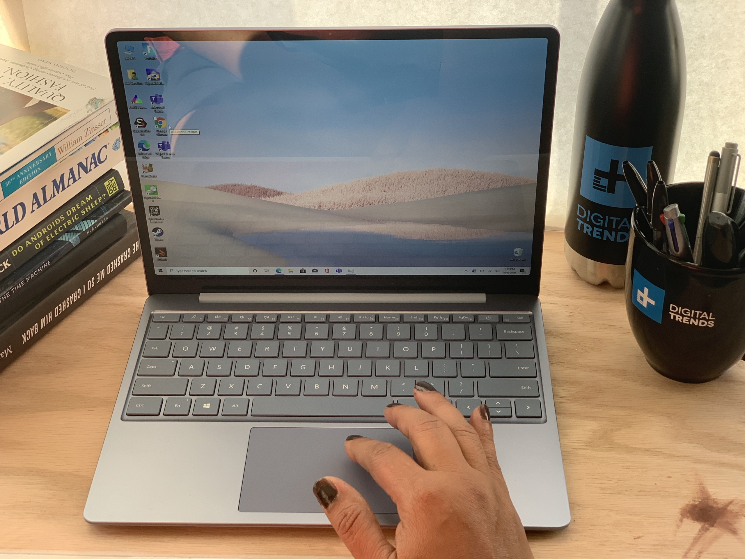 El Surface Laptop Vaya sobre una mesa con una mano usando el panel táctil.