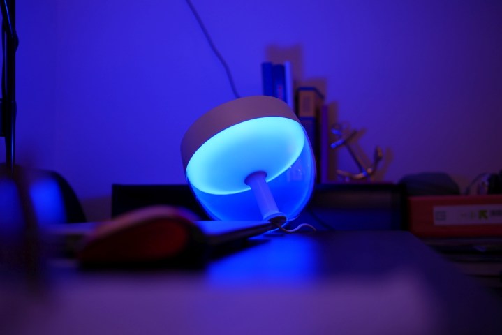 The Philips Hue Iris table lamp glowing blue.