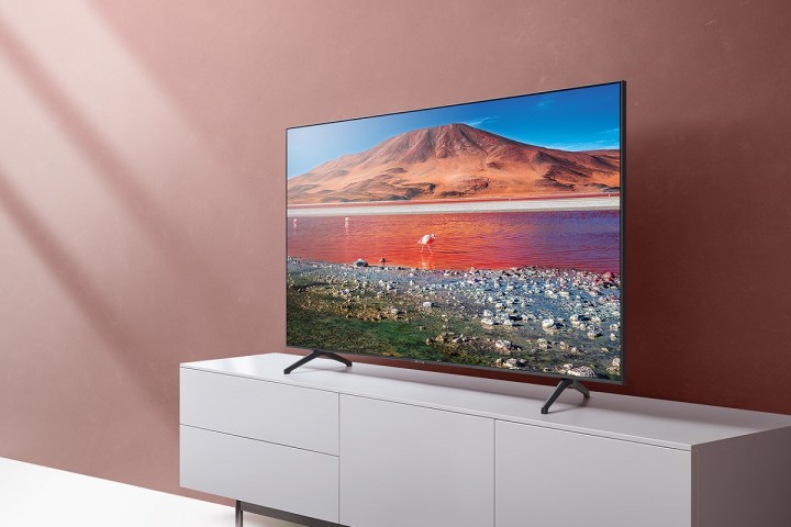 Телевизор Samsung TU7000 4K, установленный на подставку для телевизора.