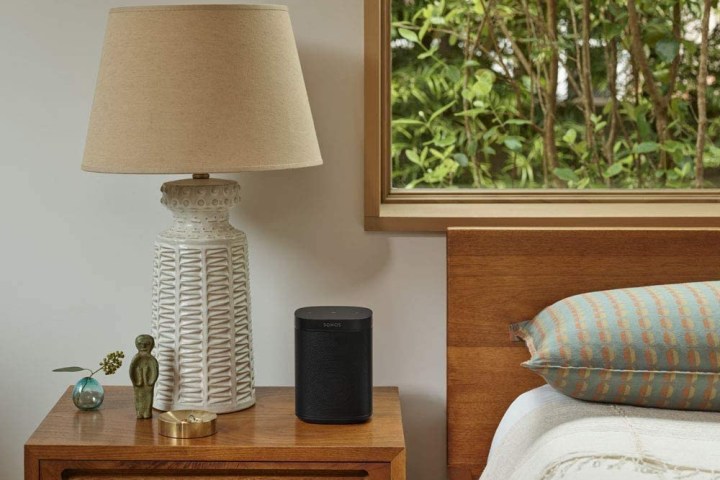 The Sonos One SL wireless speaker on a bedside table.