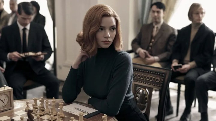 Anya Taylor-Joy ponders a chessboard in a scene from The Queen's Gambit.
