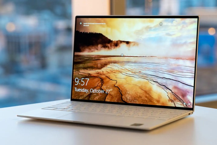 The Dell XPS 13 laptop, in white, with a nature scene on the screen.