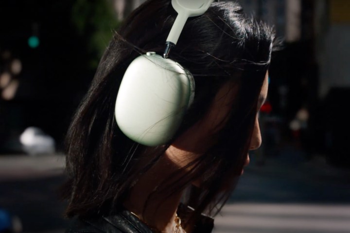 A model wears the green version of Apple AirPods Max.