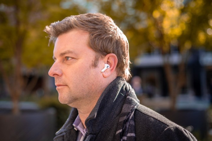 Man wearing Apple AirPods Pro outdoors.