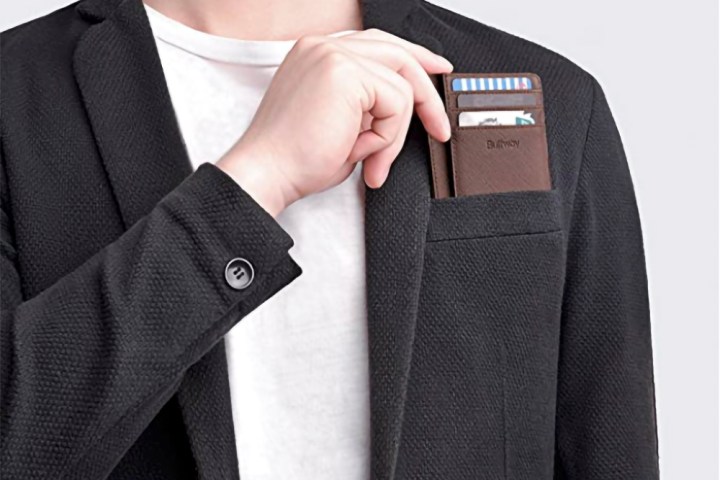 A man slides the Buffway Slim Minimalist smart wallet in brown into his jacket pocket. 