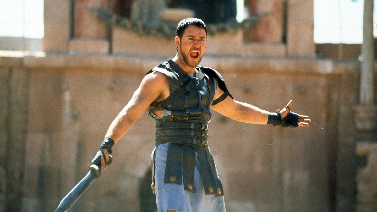 Russell Crowe extiende sus manos en la arena para Gladiator.