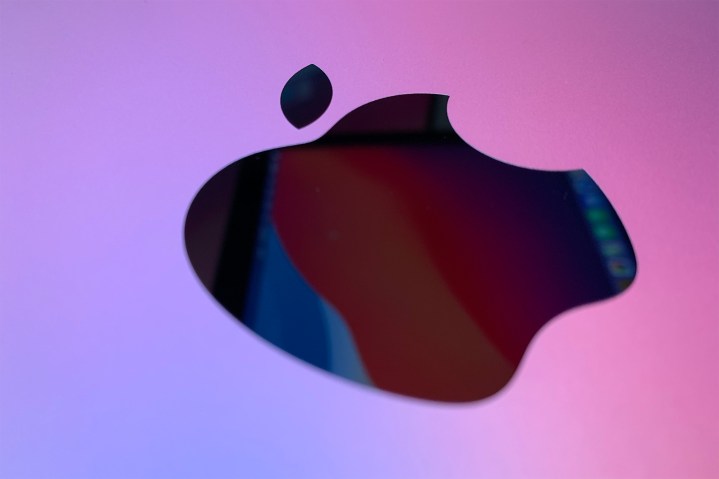 A close-up of the Apple logo on a 2020 M1 Mac Mini, with MacOS Monterey reflecting onto its surface.