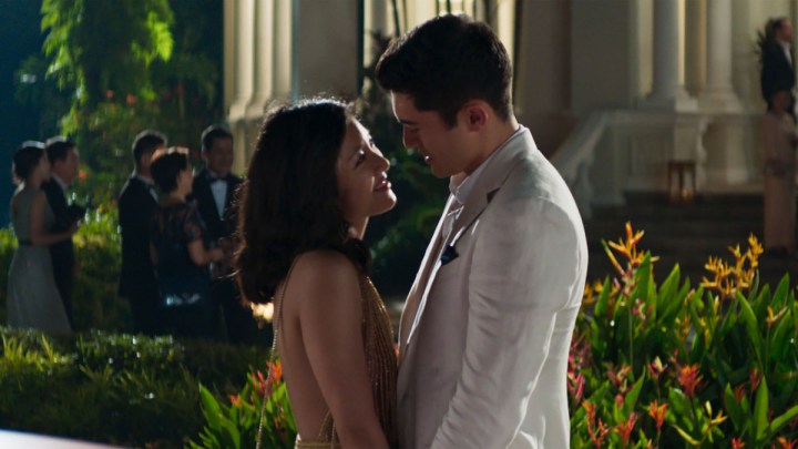 A man and a woman look at each other in Crazy Rich Asians.