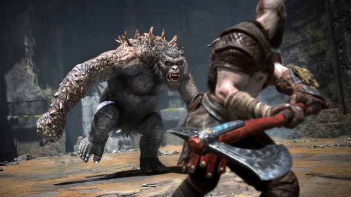 Kratos holds an ax while fighting a giant creature in God of War Ragnarok.