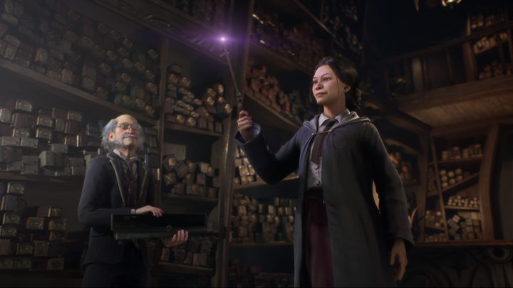 A student holding a wand in Hogwarts Legacy.