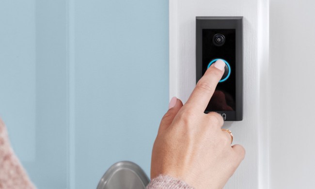 A finger pressing a Ring video doorbell.
