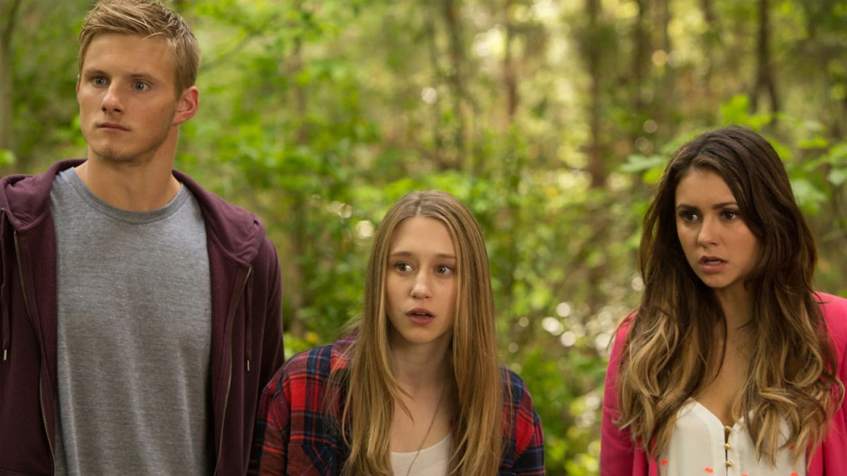 Três personagens de The Final Girls em pé na floresta. 