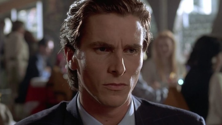 A close up of Christian Bale looking angry in a scene from American Psycho.