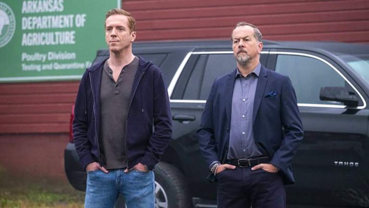 Axe and Wags standing by a car, both with hands in their pockets in a scene from Billions.