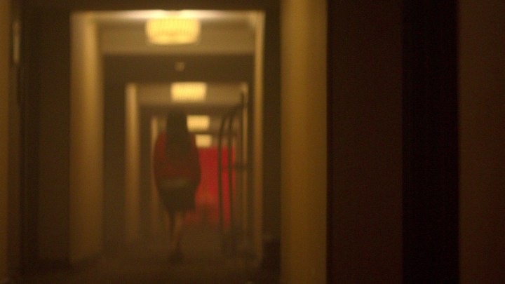 Uma mulher caminha por um corredor em Crime Scene: The Vanishing at Cecil Hotel