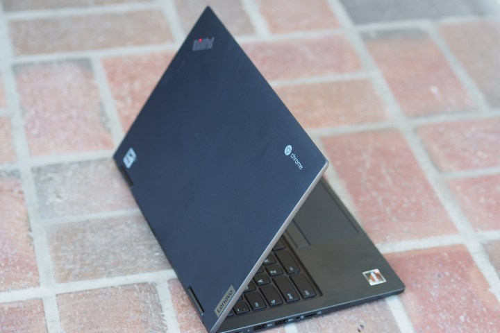 A Lenovo Chromebook on a brick floor.