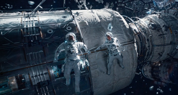 Dos astronautas flotan en el espacio.