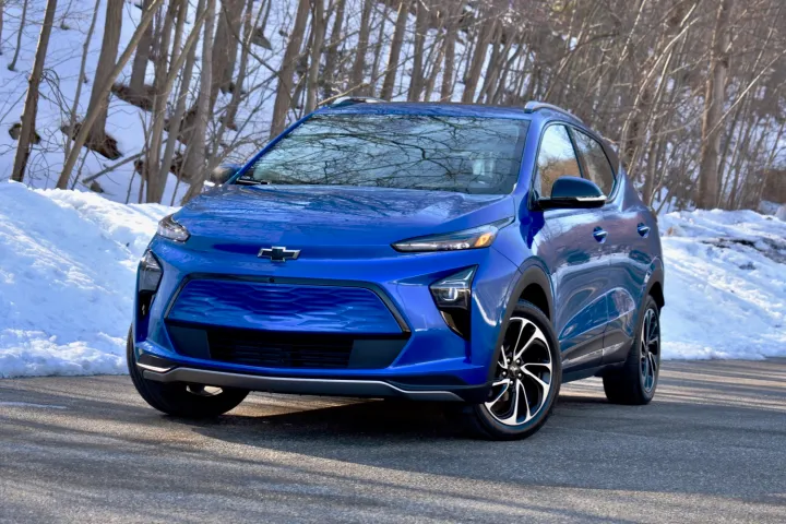 Une Chevrolet Bolt bleue sur fond de neige.