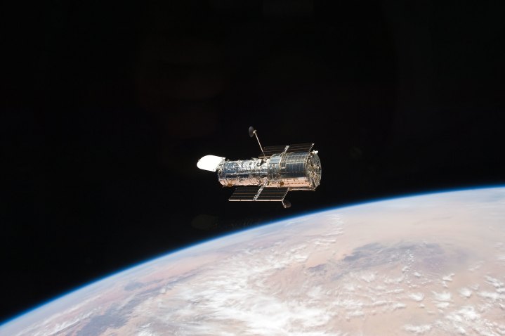 The NASA Hubble Space Telescope orbiting a planet. 