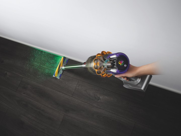 The Dyson V15 Detect using its laser sensor to find dust on the floor.