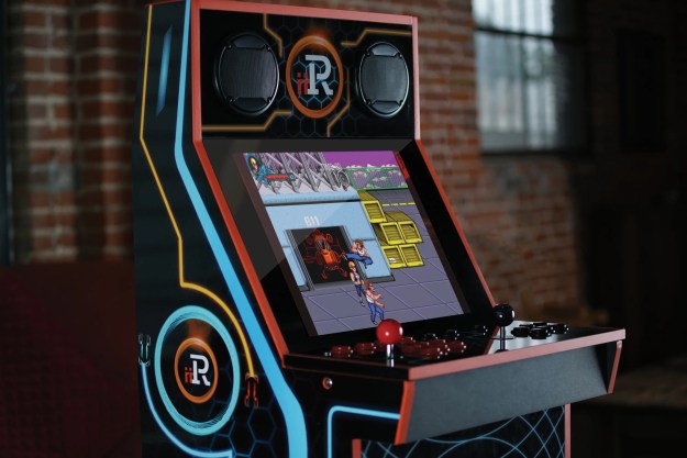 An iiRcade arcade cabinet standing against a brick wall.