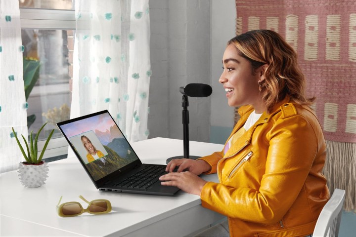 A woman sitting at a desk using the HP Envy.