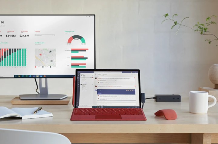The Microsoft Surface Pro 7+ on a desk, with a adviser abaft it.