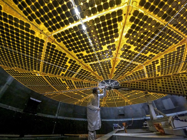 At 24 feet (7.3 meters) across each, Lucy’s two solar panels underwent initial deployment tests in January 2021. In this photo, a technician at Lockheed Martin Space in Denver, Colorado, inspects one of Lucy’s arrays during its first deployment. These massive solar arrays will power the Lucy spacecraft throughout its entire 4-billion-mile, 12-year journey through space as it heads out to explore Jupiter’s elusive Trojan asteroids