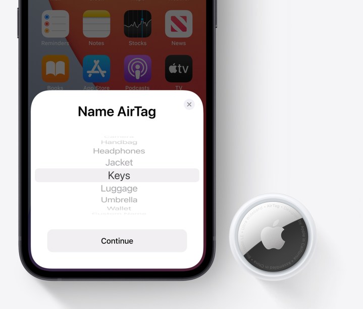 Un AirTag sentado junto a un iPhone.