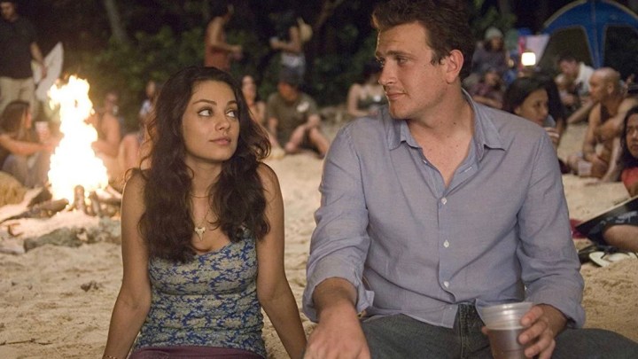 Jason Segel and Mila Kunis sit next to each other on the beach in Forgetting Sarah Marshall.