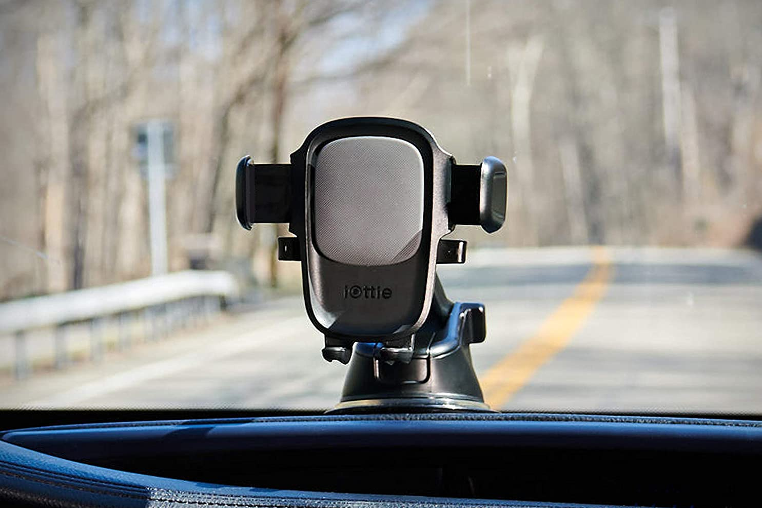 iOttie One Touch Car Mount on top of dashboard while driving along a country road.