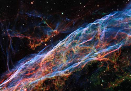 This image taken by the NASA/ESA Hubble Space Telescope revisits the Veil Nebula, which was featured in a previous Hubble image release. In this image, new processing techniques have been applied, bringing out fine details of the nebula’s delicate threads and filaments of ionized gas.