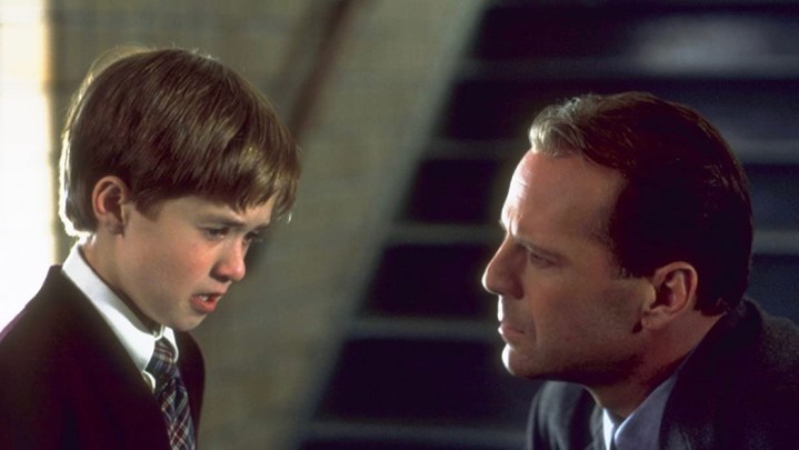A man kneeling down to face a scared-looking kid in the movie The Sixth Sense