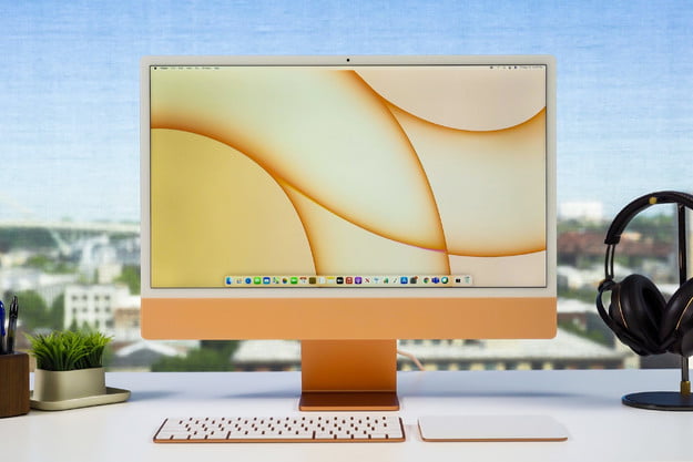 Apple iMac de 24 polegadas colocado sobre uma mesa em um contexto ensolarado.