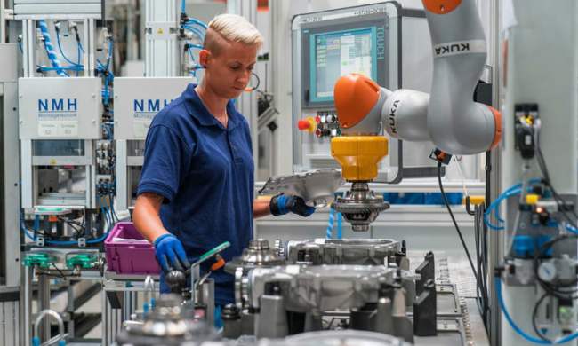 BMW factory worker using robotic arm