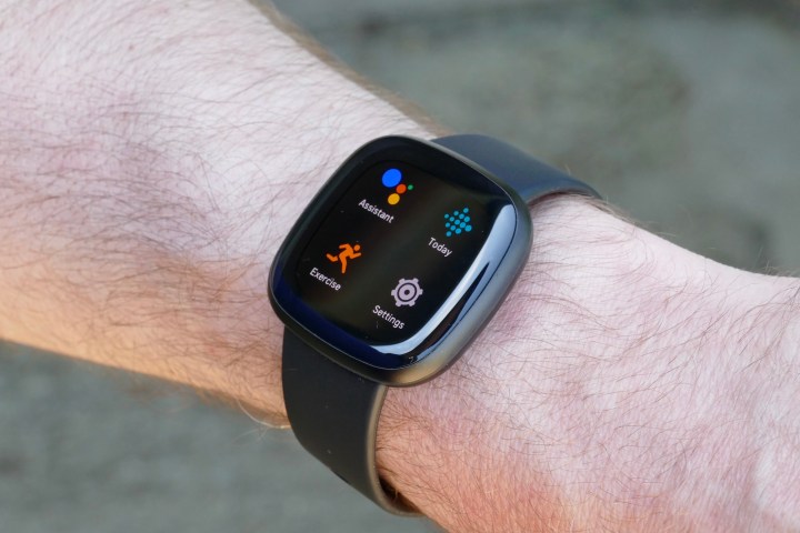 A Fitbit Versa 3 displaying its menu while on a man's wrist.