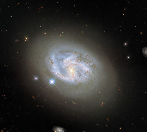 This image, taken with Hubble’s Wide Field Camera 3, features the spiral galaxy NGC 4680. Two other galaxies, at the far right and bottom center of the image, flank NGC 4680. NGC 4680 enjoyed a wave of attention in 1997, as it played host to a supernova explosion known as SN 1997bp. Australian amateur astronomer Robert Evans identified the supernova and has identified an extraordinary 42 supernova explosions. 