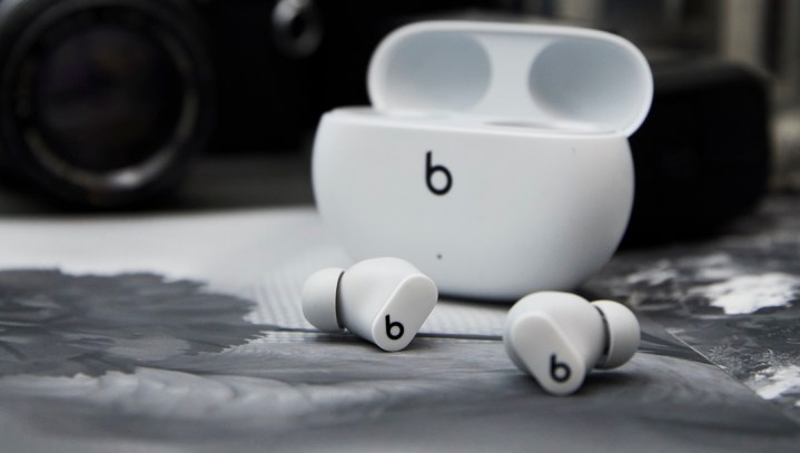 White beats studio buds with case against black background