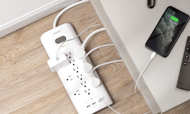 Anker 12-outlet surge protector sitting on the ground.