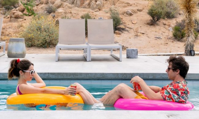Cristin Milioti and Andy Samberg sitting across from each other in a pool.