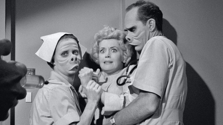 Three people huddled in a corner in The Twilight Zone.