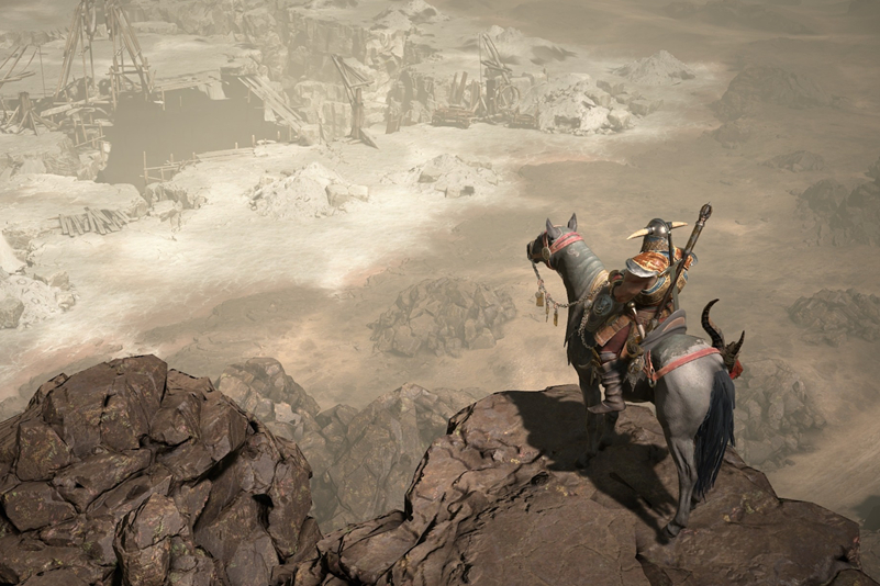 A warrior on a horse overlooking a ravine.