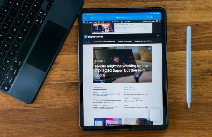 iPad Pro running iPadOS 15, with the Digital Trends homepage on the screen, Apple Pencil to the right and keyboard to the left.