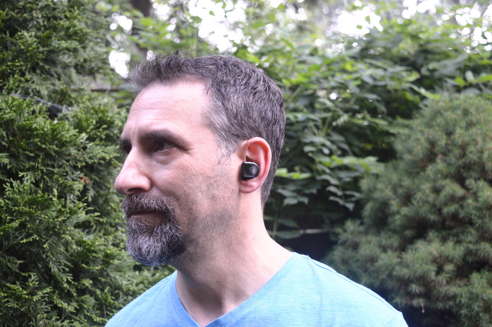 Man wearing Master & Dynamic MW08 Sport true wireless earbuds.