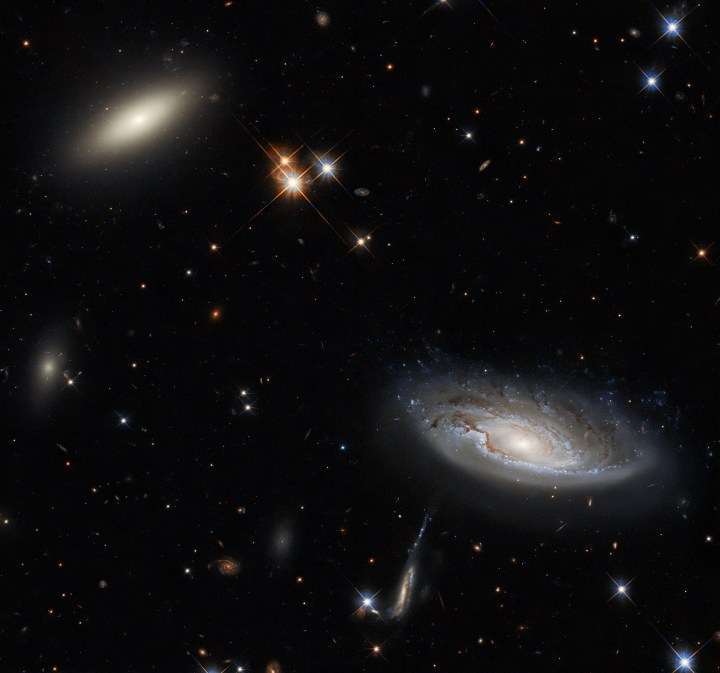 Two enormous galaxies shine. The galaxy on the left is a lenticular galaxy, named 2MASX J03193743+4137580. The side-on spiral galaxy on the right is named UGC 2665. 