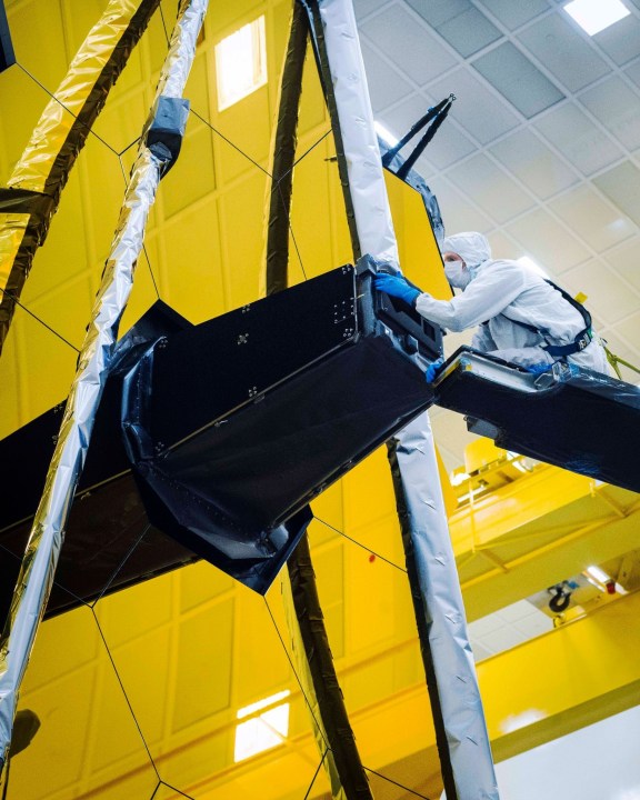 Ball Aerospace technician Larkin Carey can be seen carefully removing Webb’s "lens cap" from the Aft Optics Subsystem which has kept the observatory’s sensitive instruments clean, contaminant-free, and protected from stray light throughout the integration and test process.