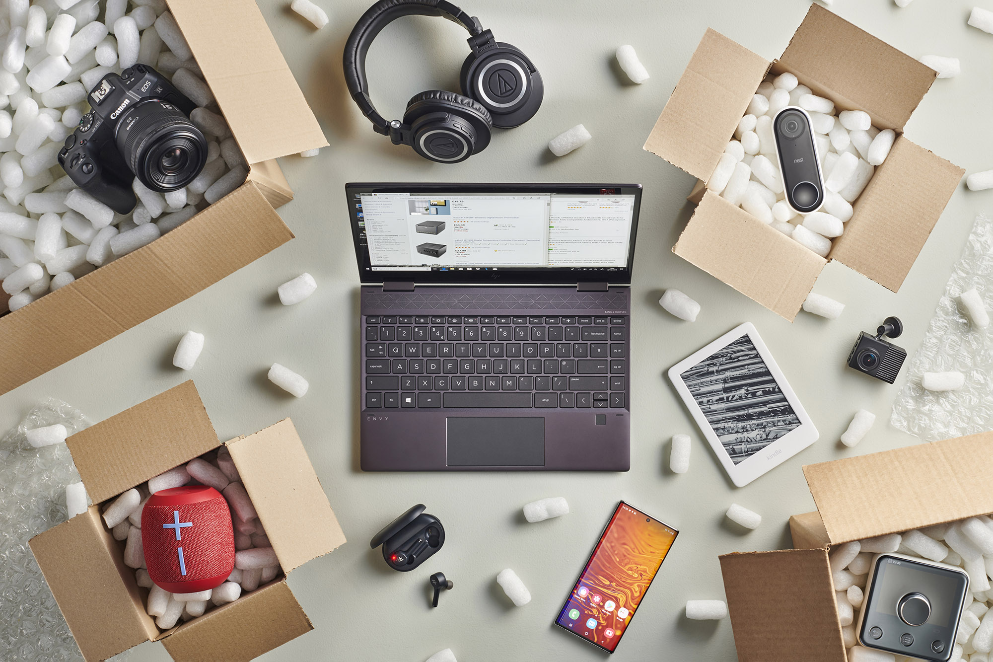Laptop en Amazon rodeada de cajas de equipos tecnológicos.