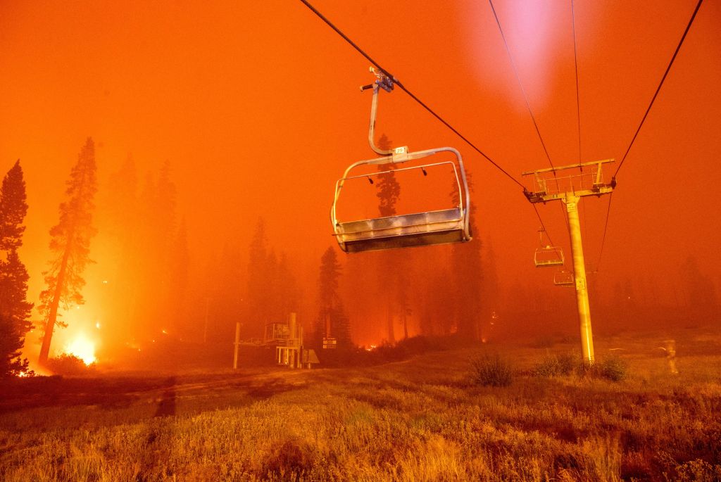 Flames from the Caldor Fire surround a chair lift at Sierra-at-Tahoe Resort.