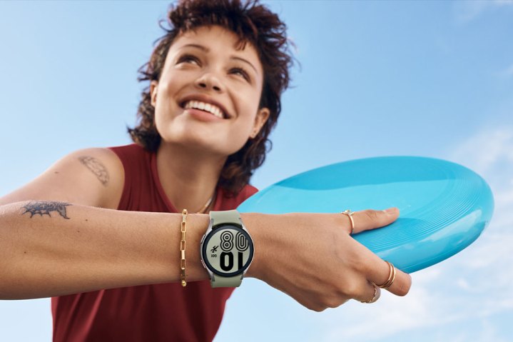 Person holding a frisbee while holding the Samsung Galaxy watch4 classic fitness.
