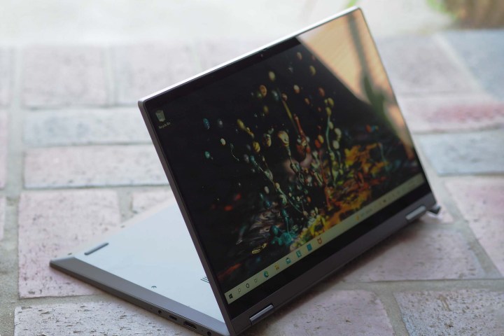 Immagine del laptop Lenovo IdeaPad Flex 5i 14 piegato all'indietro seduto a terra.